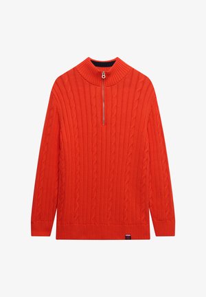 Czerwony sweter z plecionką, z wysokim kołnierzem, zamkiem błyskawicznym na ćwierć długości oraz ściągaczami przy rękawach i u dołu. Miękka struktura i wyraźny wzór.