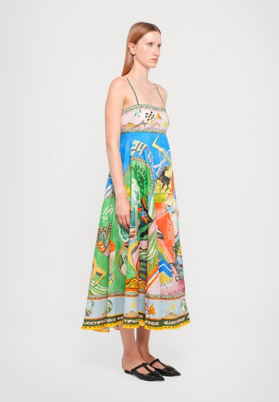 Rochie maxi colorată cu bretele subțiri, având un mix de modele verzi, albastre și roz, și un tiv decorativ galben.