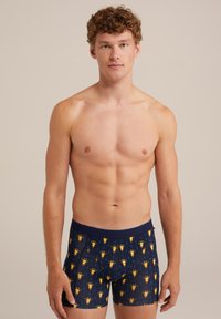 Mörkblå boxershorts med ett gult djurmönster, tillverkade av mjukt tyg, med ett elastiskt midjeband och en tight passform.