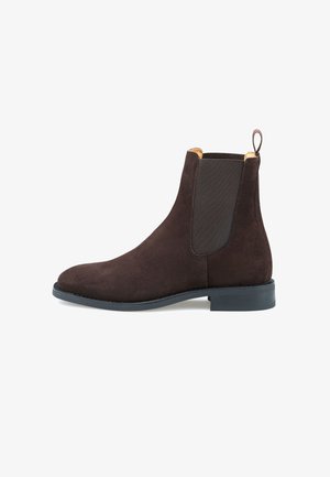 Bruine suède Chelsea-boot met elastische zijpanelen, puntige neus en een trekband aan de achterkant. Zwarte rubberen zool met een gematigd profiel.