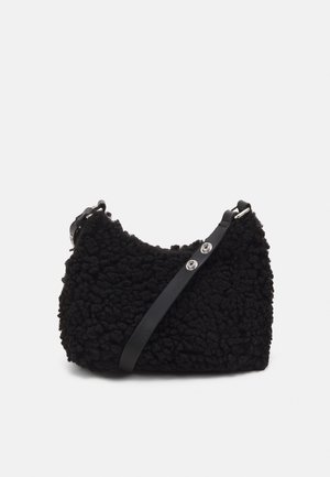 Sort tekstureret fleece skuldertaske med justerbar læderrem og sølvfarvet hardware på ensfarvet baggrund.