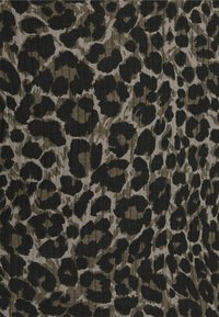 Leopardmönstrad tyg med stora svarta fläckar på en ljusbeige bakgrund. Texturen är räfflad, vilket ger designen en dimensionell känsla.