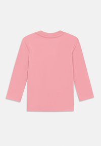Langarmshirt aus weichem rosa Baumwollmaterial, mit rundem Halsausschnitt und genähten Säumen, die hinten ein dezentes V-Form-Detail aufweisen.
