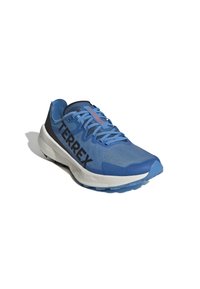 Scarpa sportiva azzurro chiaro con superiore in rete, dettagli neri e logo TERREX. Presenta una suola imbottita e battistrada testurizzato per una migliore aderenza.