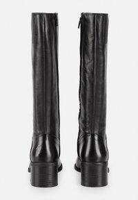 Botas de cuero negras hasta la rodilla con un acabado suave, tacón apilado y cremallera trasera. Presentan un ligero diseño embozado en el tacón.