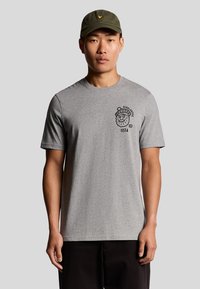 Grijze katoenen T-shirt met korte mouwen, voorzien van een zwarte grafische print op de linkerborst. Draag met een groene pet. Eenvoudig ontwerp, casual pasvorm.