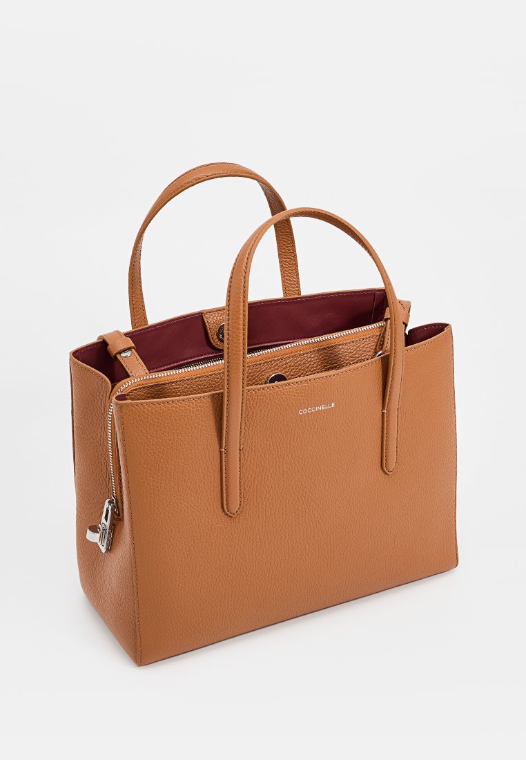 Tanfarbene Lederhandtasche mit zwei oberen Griffen, Reißverschluss und contrasting maroon Innenfutter. Verfügt über eine strukturierte Oberfläche und ein Logo-Detail.