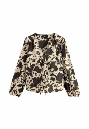 Long-sleeve blouse with a v-neckline, featuring a cream and black cow print design, gathered sleeves, and a tie detail at the front.