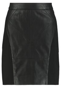 Musta nahka- ja kangashame, jossa on vartalonmyötäinen malli, kulmikkaat saumat ja sileä pinta, joissa on kontrastiväriset kangaspaneelit.