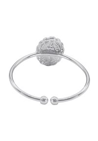 Anello d'argento con una parte superiore circolare ornata. La fascia liscia presenta due piccole perle di metallo e un motivo testurizzato sulla parte superiore.