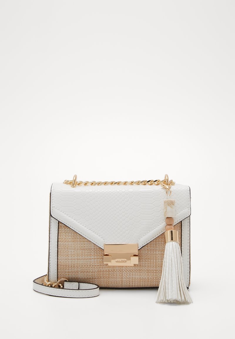 Petit sac à main rectangulaire beige tissé avec rabat blanc texturé, fermoir doré, anse chaîne et pompon blanc sur fond uni.
