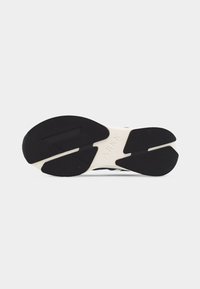 Σόλα μαύρου και λευκού παπουτσιού ARKK με διαχωρισμένο σχέδιο πέλματος και υφασμένες περιοχές για κράτημα σε λευκό φόντο.