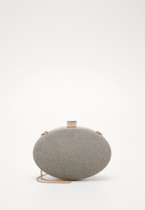 Pochette ovale en tissu gris avec un fermoir doré et une fine chaîne dorée sur fond blanc.