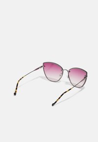 Gafas de sol estilo gato con lentes en degradado rosa, montura de metal plateado y brazos con patrón de carey. Acentos decorativos en la montura.
