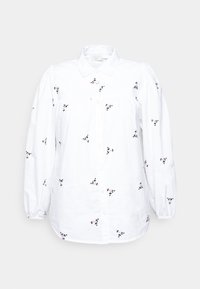 Vit button-up skjorta i bomull, med delikat svart och rosa blommönsterbroderi, samt puffade långärmar med knäppte manschetter.