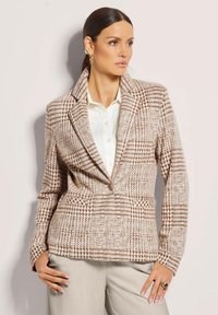Geverifieerde blazer in beige en bruine tinten, met een gegoten kraag, enkele knoopsluiting en zijzakken; textuurstof.