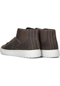 Bruine leren high-top sneakers met gestructureerde stoffen panelen, witte rubberen zolen en gestikte details op de hak en zijkanten.