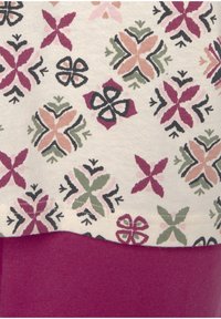 Cotton fabric features a floral pattern in pink, green, and dark hues above a solid burgundy section, with visible stitching along the seam.