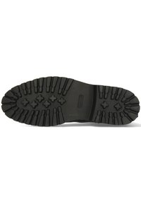 Suela de goma negra con patrón de tracción profundo; presenta varias crestas y ranuras para mayor adherencia. Textura duradera adecuada para uso en exteriores.
