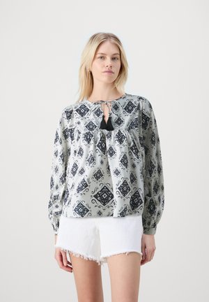 Lightweight patterned blouse in gray with black abstract designs, featuring a round neck, tie closure, and relaxed fit long sleeves.