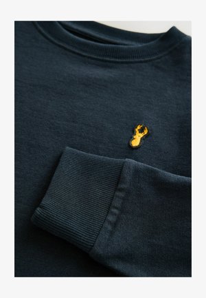Donkerblauwe sweatshirt met een geribbelde kraag en manchetten, voorzien van een klein geel geborduurd kreeft ontwerp op de borst. Glad textuur.
