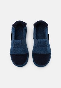 Blue felt slippers with dark navy accents, a slip-on design, rounded toe, and elastic band for a secure fit. Soft texture overall.