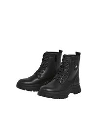 Botas negras de tobillo hechas de cuero suave, con diseño de cordones, cremallera lateral, suela texturizada y un logotipo circular en el lado exterior.