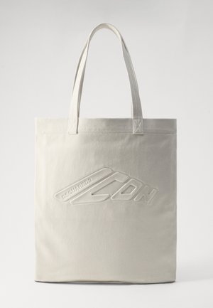 Beige Leinentasche mit zwei Griffen, ausgestattet mit einem geprägten Logo und rechteckiger Form. Glatte Textur mit verstärkten Nähten.