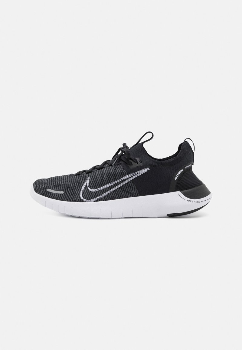 Chaussure de course Nike noire et grise avec semelle blanche, tige en maille et grand logo swoosh sur le côté, vue de l'extérieur.