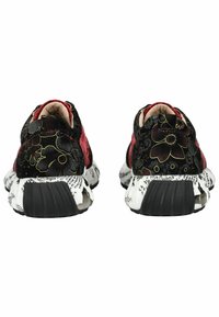 Sportovní boty s černým květinovým potiskem, červenými akcenty a bílou texturovanou podrážkou se vzorem textu a černou gumovou podrážkou.
