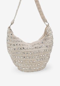 Bolso de hombro de ganchillo beige con lentejuelas metálicas dispuestas en rayas horizontales, con una correa sencilla y fondo redondeado.