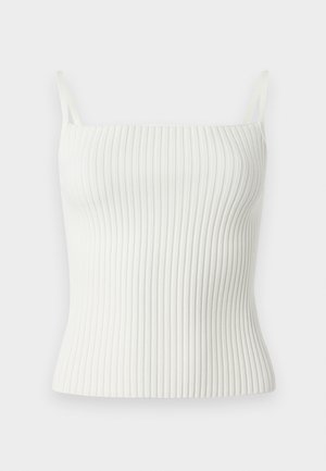 Débardeur blanc à côtes avec fines bretelles, présentant un design ajusté et une texture douce. Le matériau est extensible et lisse, améliorant le confort.
