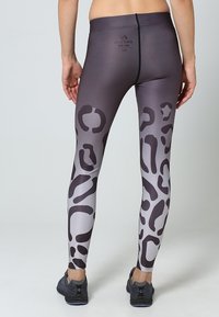 Leggings attillati in gradiente di grigio e nero con un motivo a leopardo. Realizzati in materiale liscio e elastico; presentano una vita alta e dettagli di cucitura.