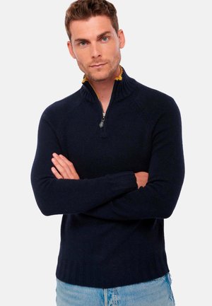 Marineblauer Zip-Kragen-Pullover mit geripptem Kragen und Bündchen. Hergestellt aus strukturiertem Stoff mit kontrastierendem Innenkragen. Figurbetontes Design.