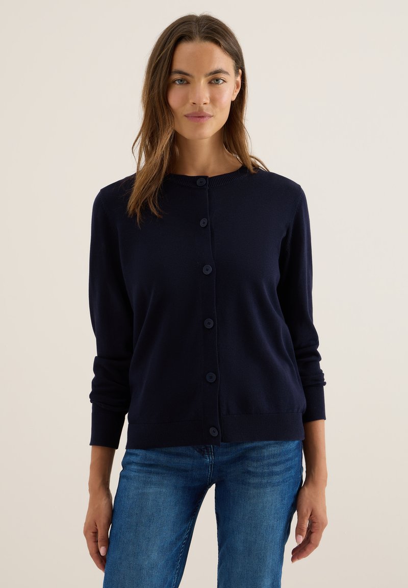 Navyblauwe gebreide cardigan met een ronde hals, lange mouwen en zes bijpassende knopen aan de voorkant. Gladde textuur en getailleerde stijl.