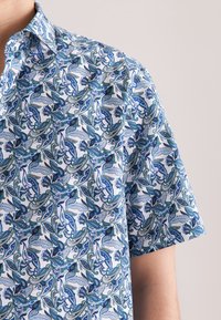 Korte mouwen overhemd van witte stof met een blauwe en groene paisleyprint, met een spreidkraag en een ontspannen pasvorm.