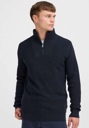 Navy Pullover mit Reißverschlusskragen, ausgestattet mit einem strukturierten Strickdesign, gerippten Bündchen und einem leichten Schlitz am Saum für zusätzlichen Komfort.