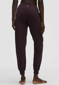 Burgundijas sportiskie bikses ar pieguļošu jostasvietu, šaurām piedurknēm un sānu kabatām, izgatavotas no gludas, elastīgas auduma ar matētu apdari.