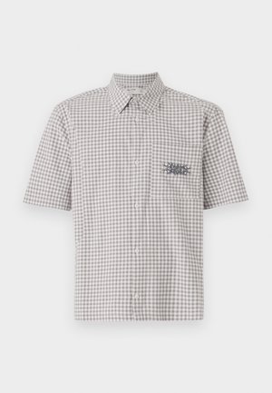 Camisa de manga corta con cuello en un patrón de cuadros gris y blanco. Presenta un bolsillo en el pecho con un diseño gráfico en contraste.