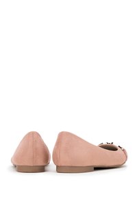 Ballerines en suède rose avec un bout arrondi, un talon plat et un détail de nœud décoratif à l'avant. Texture lisse avec des accents de couture subtils.