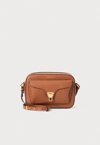 Tan leather crossbody bag with a textured finish, featuring a front flap pocket and gold-tone hardware. Adjustable strap included.