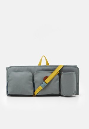 Bolsa rectangular gris con tres bolsillos frontales, asa amarilla y correa ajustable sobre fondo blanco.