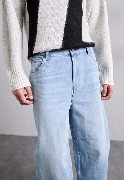 Ανοιχτό μπλε τζιν παντελόνι με άνετη εφαρμογή, διαθέτοντας διακριτική φθορά, λεπτομέρειες ραφής και κλασικό σχέδιο με πέντε τσέπες.