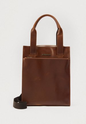 Hnedá kožená taška cez rameno s dvoma hornými rukoväťami a nastaviteľným popruhom. Má predné vrecko na zips a vyrazené logo, hladká textúra.