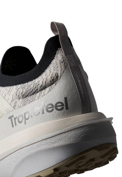 Baskets gris clair avec un dessus en tissu texturé, un col noir contrastant, un logo bien en vue et une semelle rembourrée avec un motif de semelle.