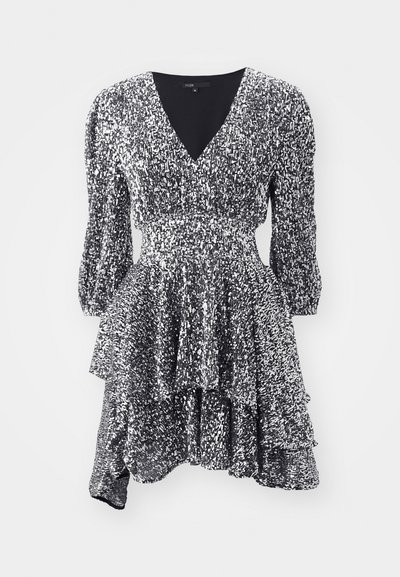 Robe en sequins argentés avec un décolleté en V profond, des manches bouffantes et un ourlet à volants superposés, présentant une taille ajustée et une texture scintillante.