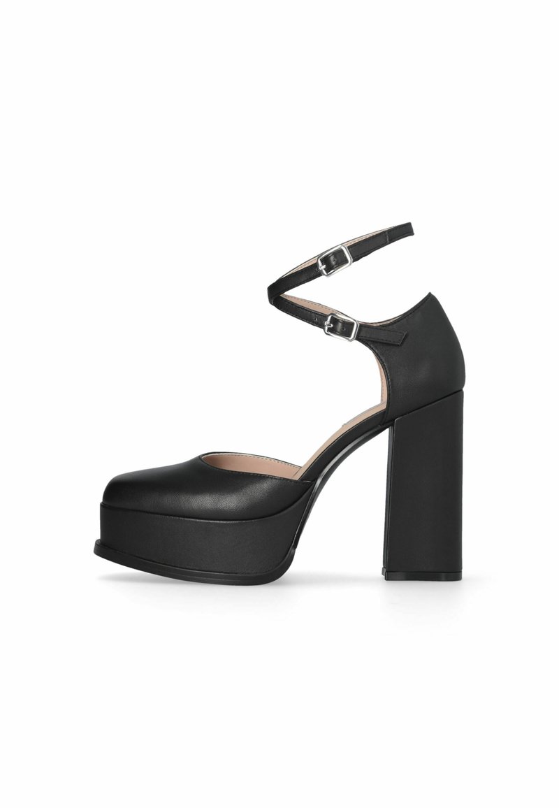 Chaussure à talon haut à plateforme noire avec bout arrondi, talon bloc épais, et doubles brides de cheville avec boucles argentées sur fond blanc.