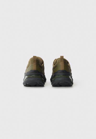 Green athletic shoes with a mesh upper, black rubber sole, and padded collar, featuring pull tabs at the back for easy wear.