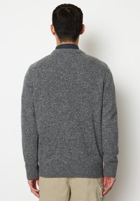 Grau strukturierter Pullover mit rundem Ausschnitt sowie gerippten Bündchen und Saum. Das Strickmuster weist ein dezentes meliertes Design auf.