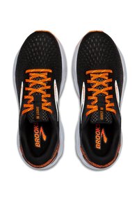 Svarta sportskor med orange snören och detaljer. Mesh-övre med en texturerad design och vita logotyper. Dämpad, ljusgrå sula.